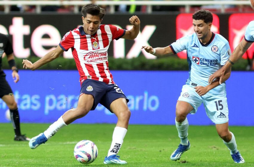 Under pressure from Cruz Azul's Ignacio Rivero, Yael Padilla fires off a shot in minute 90+7. Padilla's goal gave Guadalajara a 1-0 win and clinched a spot in the Liga MX playoffs for the Chivas. (Photo by ULISES RUIZ/AFP via Getty Images)