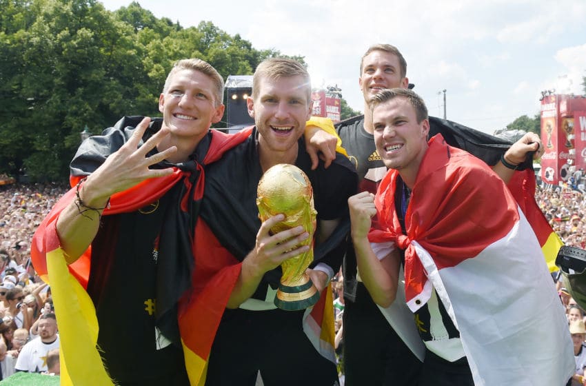 BERLIN, GERMANY - JULY 15: Bastian Schweinsteiger, Per Mertersacker, Manuel Neuer and Kevin Grosskreutz celebrate during the German team victory ceremony on July 15, 2014 in Berlin, Germany. Germany won the 2014 FIFA World Cup Brazil match against Argentina in Rio de Janeiro on July 13. (Photo by Markus Gilliar - Pool /Getty Images)